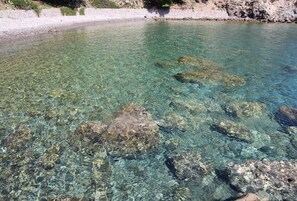 Una vista despejada de una costa rocosa con aguas poco profundas.