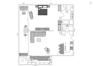 A floor plan of a hotel room with a bed, seating area, kitchenette, bathroom, and a small balcony.