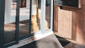 A revolving door with a sign reading "Via Lavizzari 6" and a public telephone box on the wall.