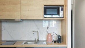 A kitchen with a microwave, a kettle, and a coffee maker on the countertop. - New Deluxe Studio 1 - Downtown Thessaloniki-fully Equipped (Thessaloniki)