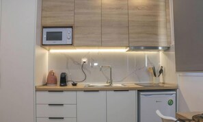 Une cuisine moderne équipée d’un four à micro-ondes, d’une machine à café et d’un lave-vaisselle.
