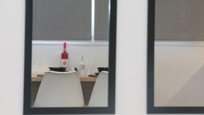 A dining area with a table set for two, a wine bottle, and a glass. - New Studio 4 Downtown Thessaloniki-fully Equipped (Thessaloniki)