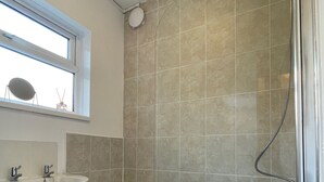 A bathroom with a bathtub, a sink, and a window. - Lovely 2-bed Downstairs Apartment (Gateshead)