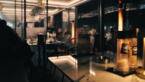 A modern kitchen with a glass partition, stainless steel appliances, and a bar area with bottles. - Karakoy Aparts Hotel (Istanbul)