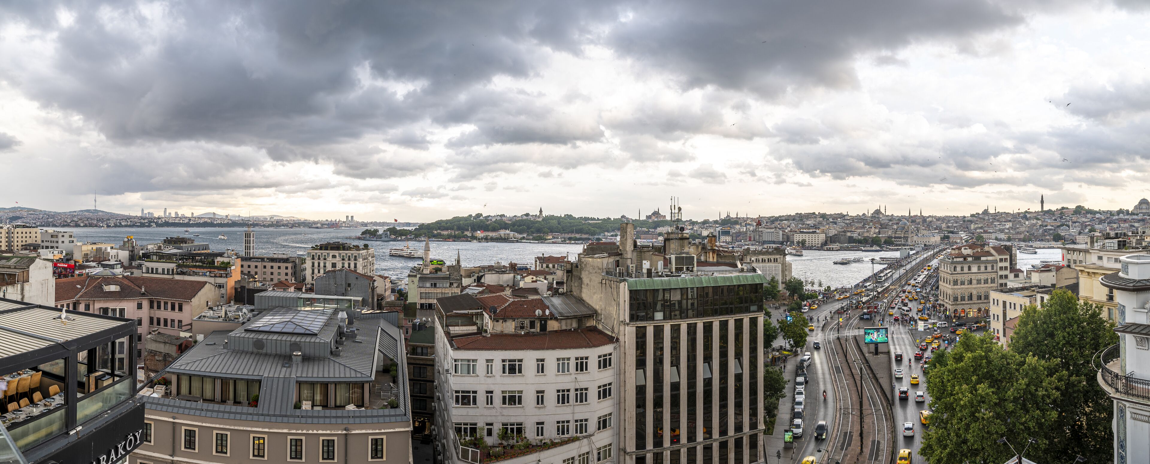 A cityscape with a river, buildings, and a tram line.