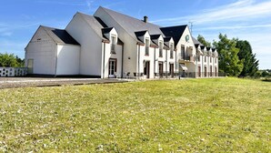 A large, multi-story building with a symmetrical facade, featuring a central entrance and multiple windows. - Logis Hôtel Sully le Château (Saint-Père-sur-Loire)