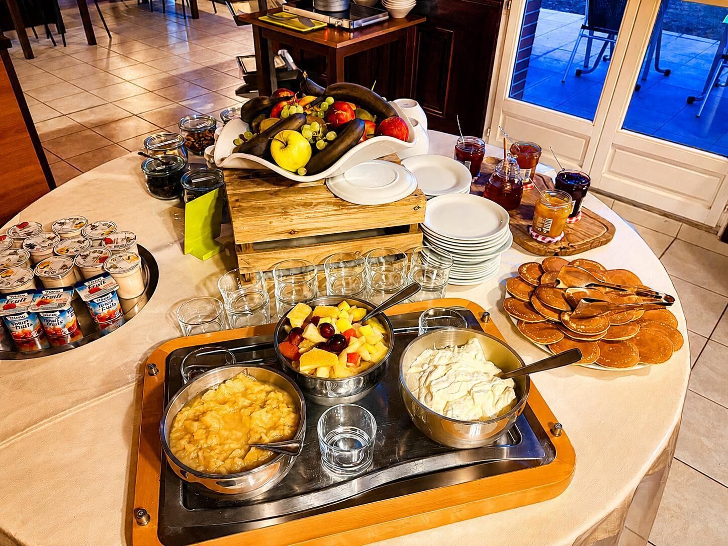 Montaje de bufé con diversas opciones de comida, incluyendo frutas, pasteles y bebidas.