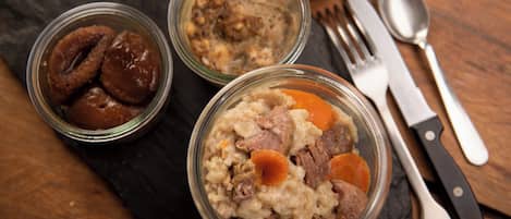 Tres tazones de vidrio con comida sobre una superficie de pizarra oscura, con un cuchillo y un tenedor a un lado.