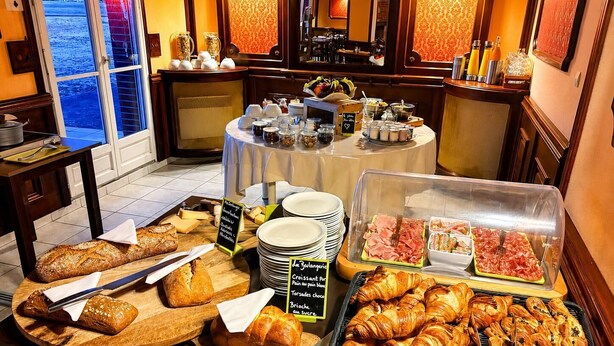A breakfast buffet with various breads, pastries, and meats. - Logis Hôtel Sully le Château (Saint-Père-sur-Loire)