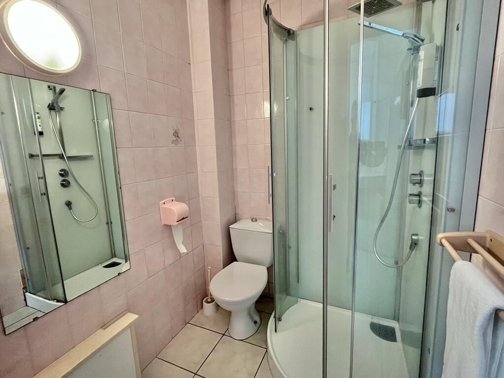 Une salle de bain moderne avec une douche à parois de verre, des toilettes et un lavabo avec un miroir.