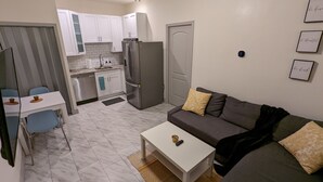 A compact living space with a kitchenette, a dining area, and a seating area with a sofa and a coffee table. - Fully Stocked Tampa Apartment (Tampa)