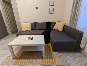 Relax in this stylish living room with a comfortable sofa, coffee table, and artwork on the walls.