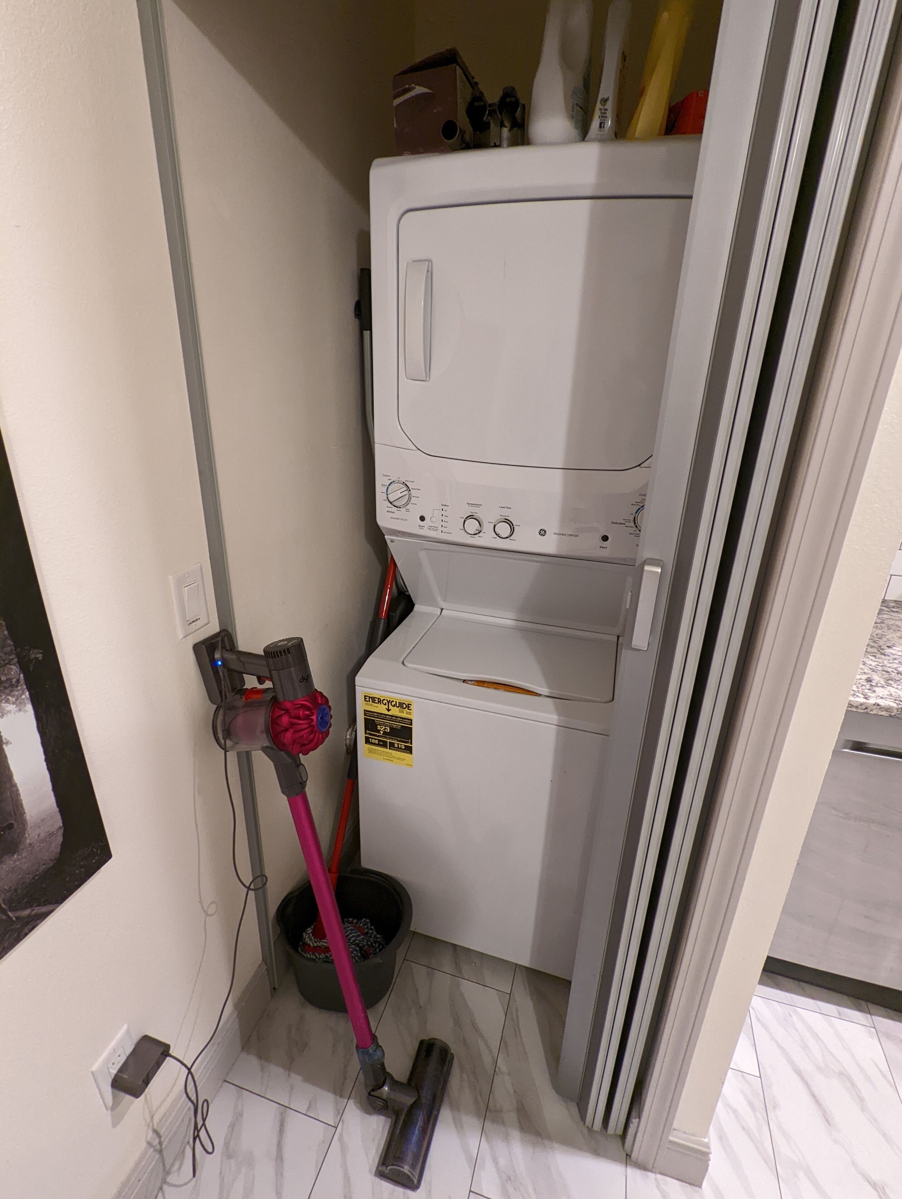 A laundry room with a washing machine, a dryer, and a mop.