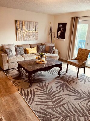 A living room with a sofa, coffee table, patterned rug, and a chair. - Lovely Clean Bright top floor unit Coin Op Laundry (Fairbanks)
