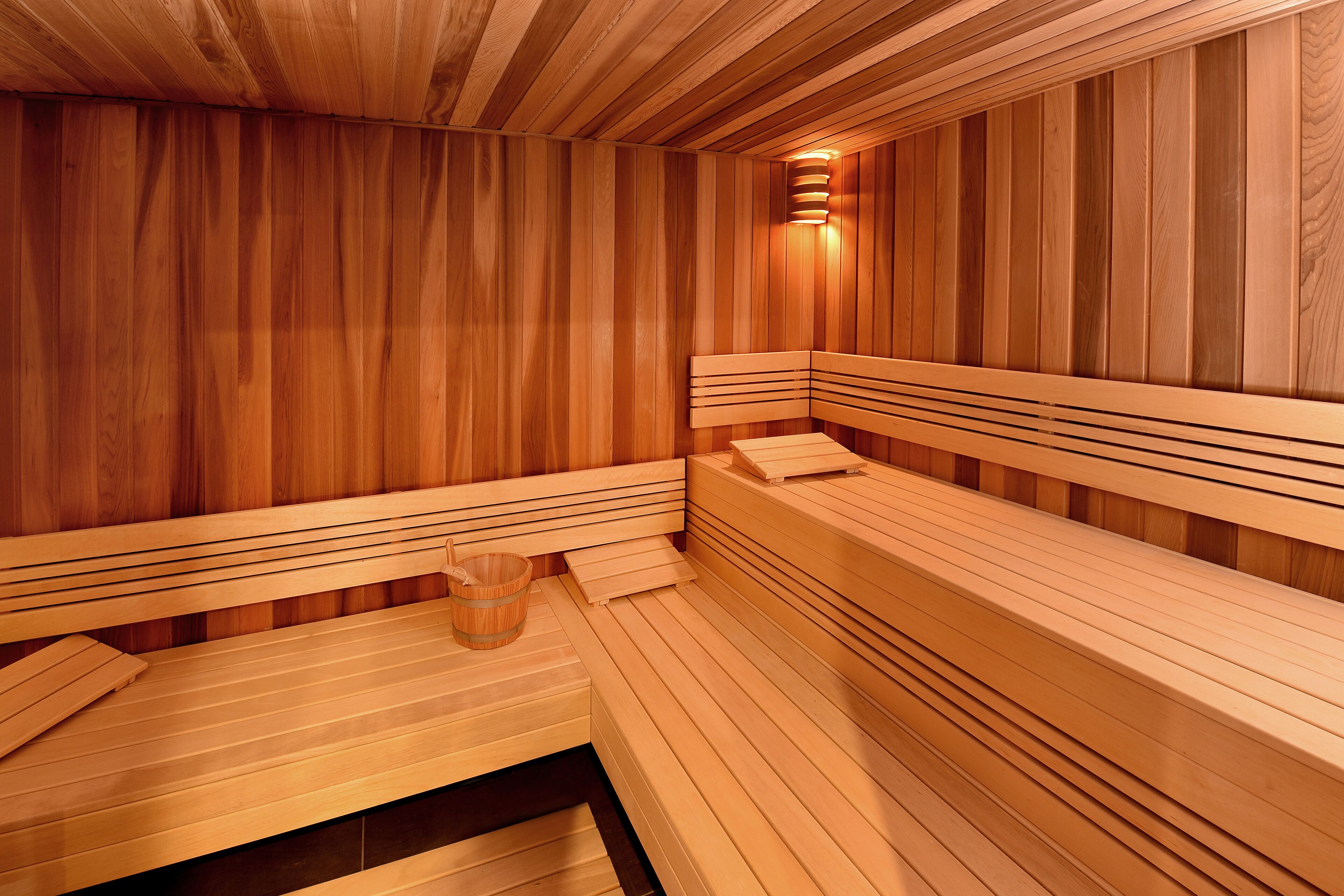 Una sauna amb bancs de fusta i un seient.