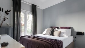 A bedroom with a bed, bedside table, and a window with curtains. - Unique 2BR Apartment in Filothei (Filothei-Psychiko)
