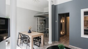 A modern interior with a dining area, a white shelving unit, and a hallway leading to another room. - Unique 2BR Apartment in Filothei (Filothei-Psychiko)