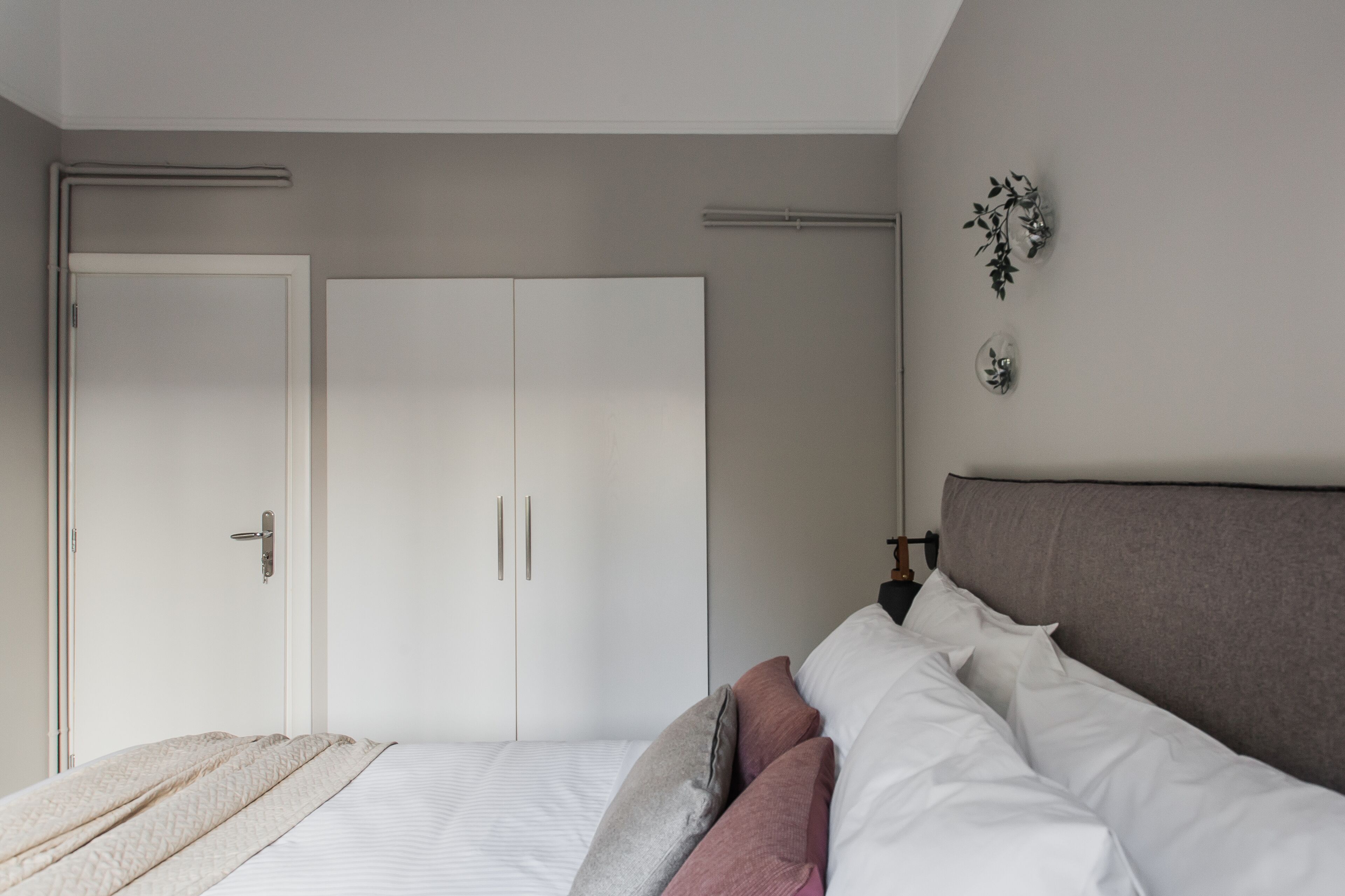 Quarto com uma cama, um guarda-roupa e uma mesa de cabeceira.