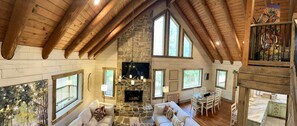 Cozy seating area with fireplace, dining table, and outdoor views.