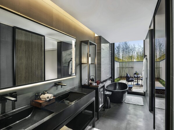 A modern bathroom with a large mirror, black countertops, and a black bathtub. - Pullman Nanchang Meiling (Nanchang)