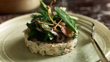 Un plato con un alimento en capas, adornado con hierbas y una ramita.