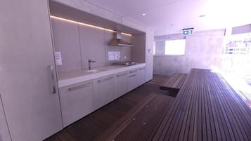 A modern kitchen with a built-in sink, stainless steel cabinets, and a wooden floor.