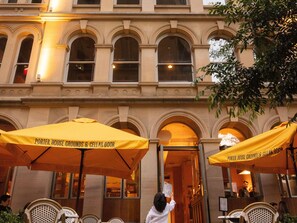 A building with arched windows and a yellow awning that reads 'Porter House Grounds & Cellar Door.'