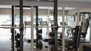 Une salle de sport équipée de matériel de musculation, de tapis de course et d’appareils d’exercice.