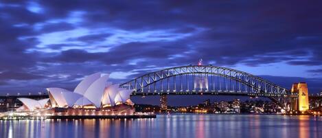 The Sydney Opera House and Sydney Harbour Bridge at night.