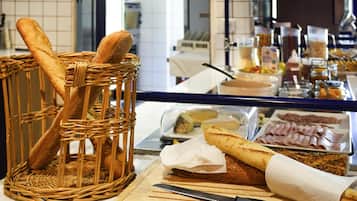 Un plan de travail de cuisine avec du pain, un couteau et divers aliments.