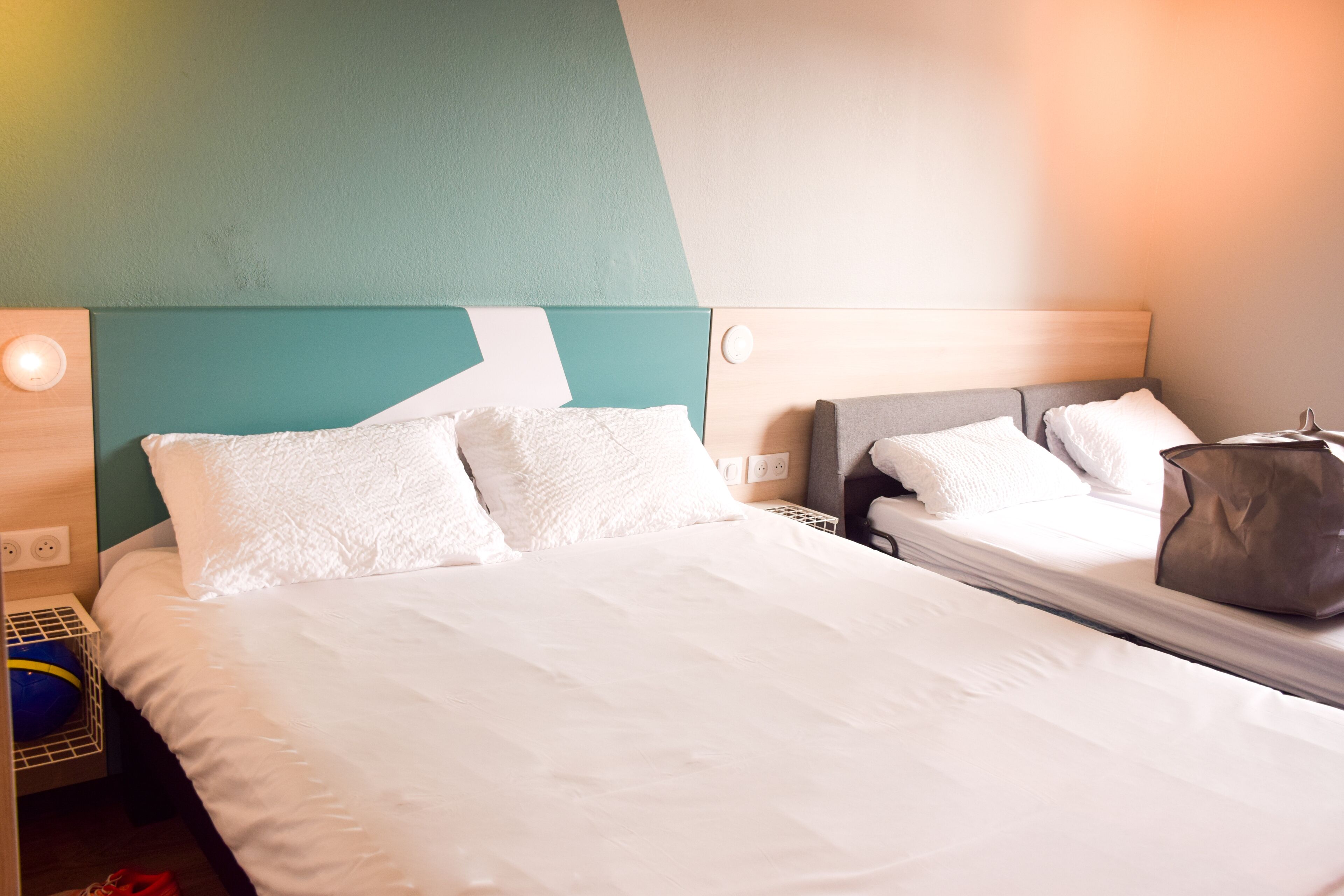 Una habitación de hotel con una cama grande, una mesita de noche y una mesilla.
