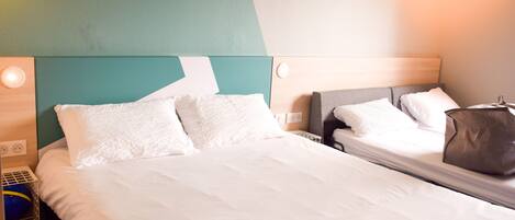 Una habitación de hotel con una cama grande, una mesita de noche y una mesilla.