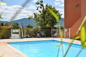 Una piscina al aire libre de temporada, sillones reclinables de piscina