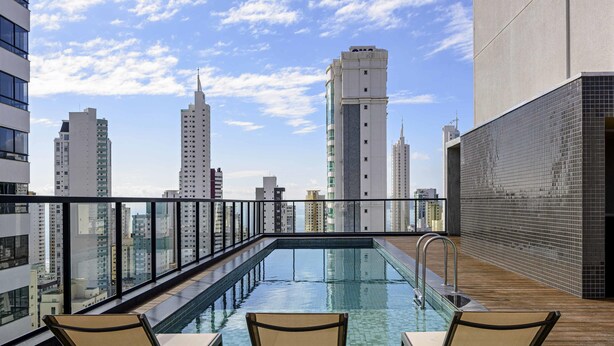 A rooftop pool with clear views of surrounding high-rise buildings. - Ibis Plaza Balneario Camboriu (Balneário Camboriú)