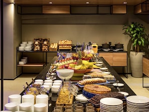A buffet setup with various food items and serving utensils. - Ibis Plaza Balneario Camboriu (Balneário Camboriú)