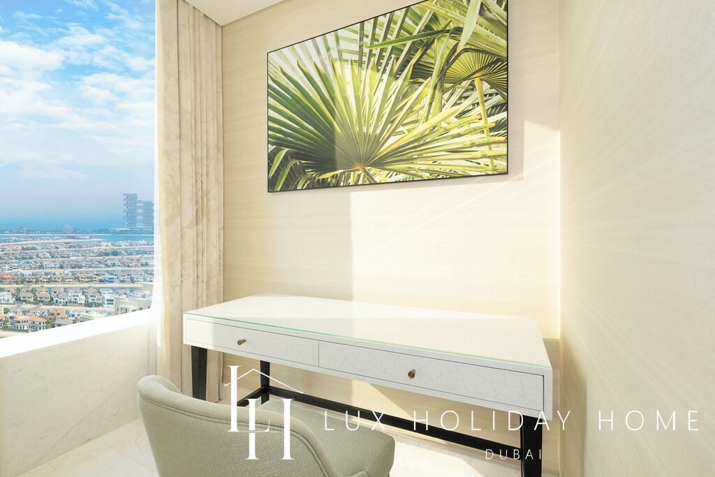A modern bedroom with a city view, a glass desk, and a large window.
