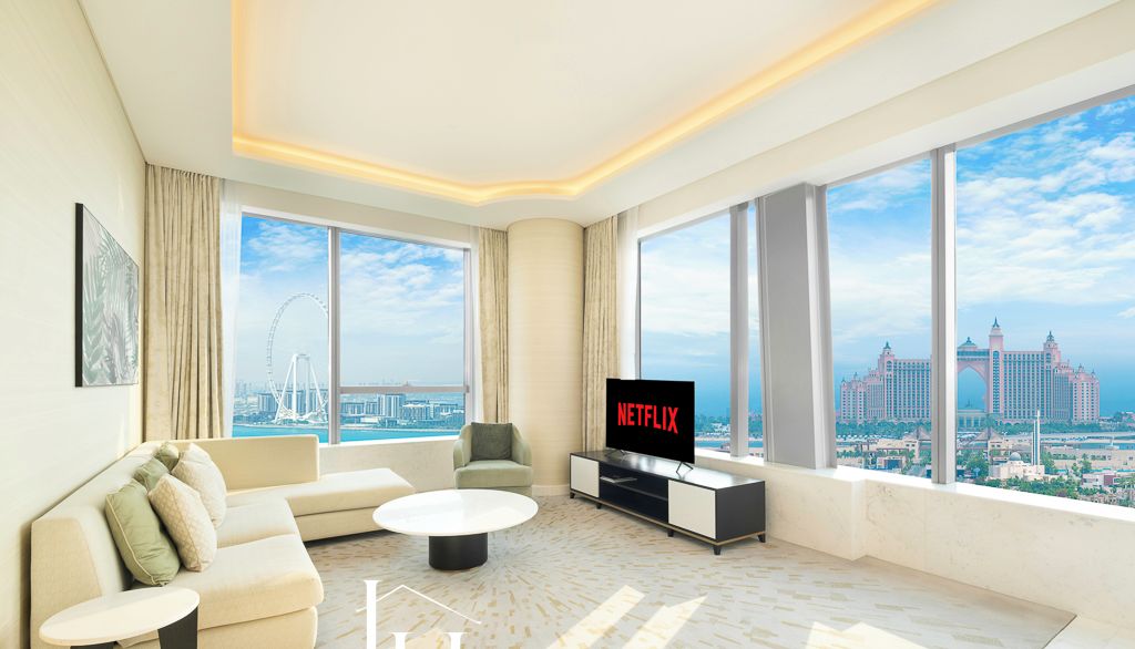 Un saló modern amb un sofà, una taula de centre i una televisió, grans finestres amb vista a la ciutat, i un cartell de 'NETFLIX' a la bonilla.