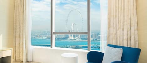 A modern living room with a view of a Ferris wheel and Dubai skyline.