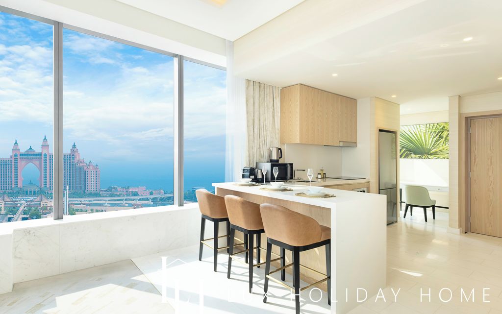 A modern kitchen with a large island, bar stools, and a view of a cityscape.