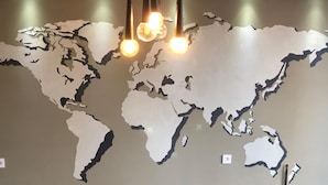 A world map mural with hanging lights.