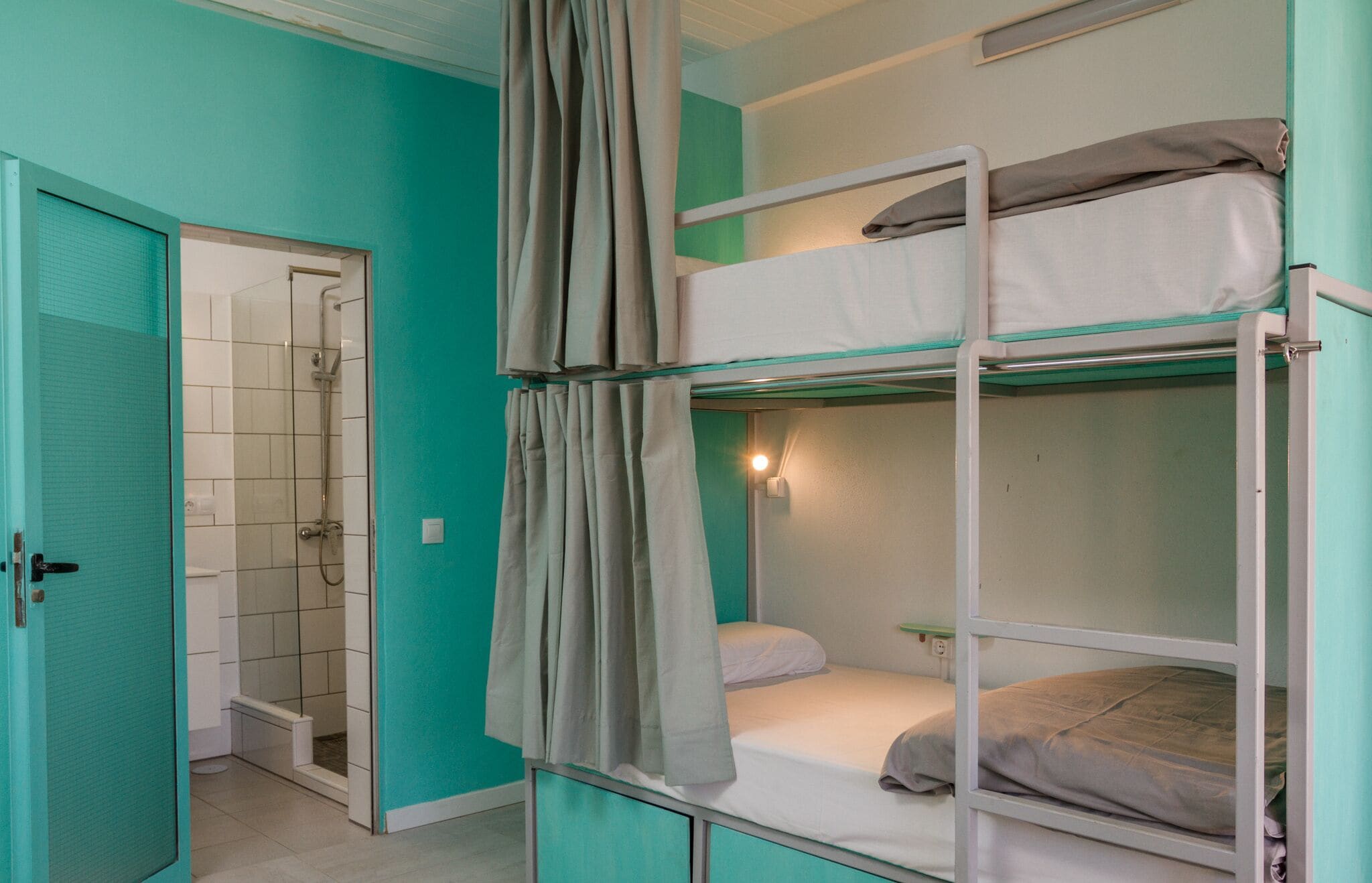 Habitación con literas y zona de ducha.