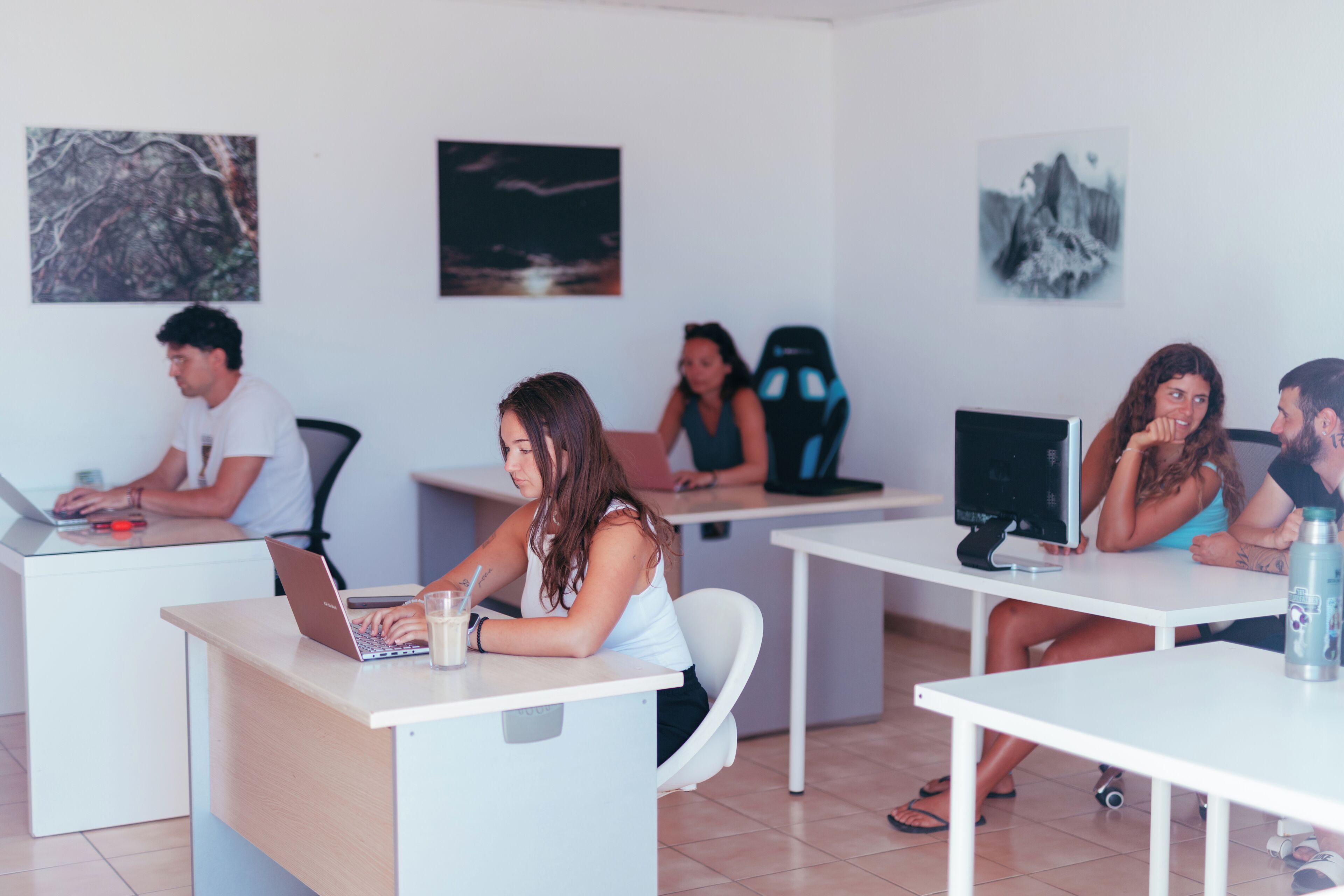 Ein moderner Arbeitsbereich mit weißen Schreibtischen, Computern und Stühlen.