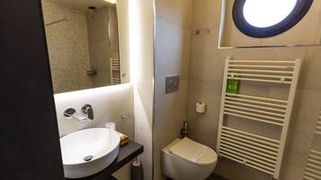 Un bagno con lavandino, WC e portasciugamani.