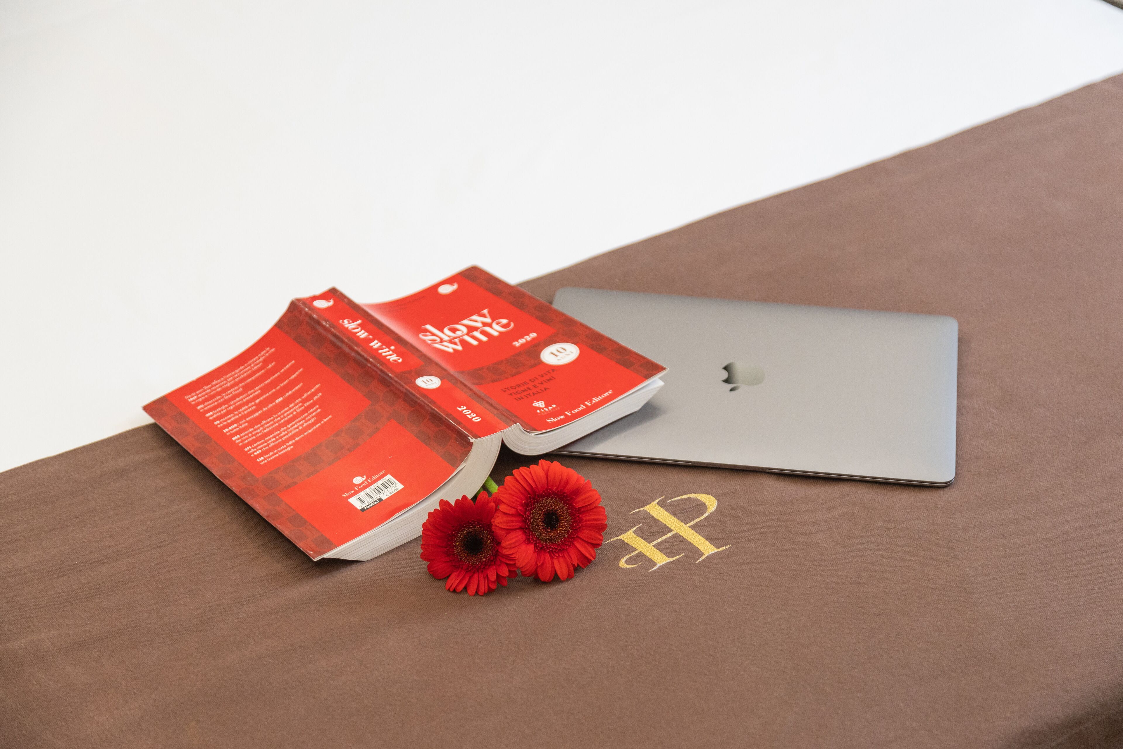 A laptop and a book on a brown surface.