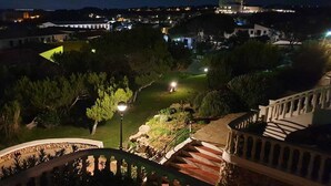 A nighttime view of a residential area with a well-lit staircase and a garden.