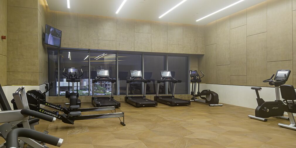 A gym with treadmills, elliptical machines, and weight equipment.