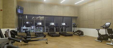 A gym with treadmills, elliptical machines, and weight equipment.