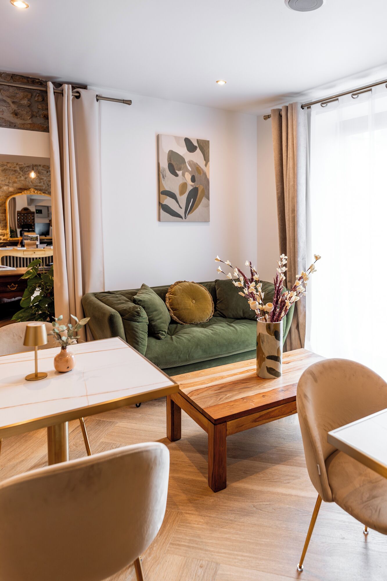 A modern living room with a green sofa, a coffee table, and a dining area with a table and chairs.