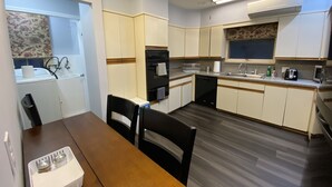 Una cucina compatta con zona pranzo, comprensiva di tavolo, sedie e ventilatore a soffitto.