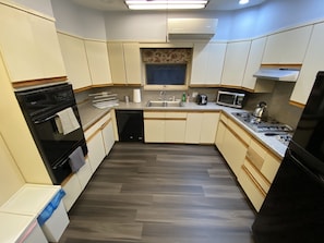 Cocina compacta equipada con lavavajillas, horno, microondas y cocina a gas.